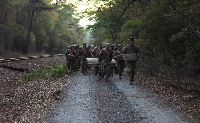 Infantry recruits with Bravo Company, 1st Battalion, 50th Infantry Regiment, complete a resupply mission during the First 100 Yards at Fort Benning, Georgia, March 30, 2023. The 90-minute event teaches new recruits how to quickly work together to accomplish the mission. 
