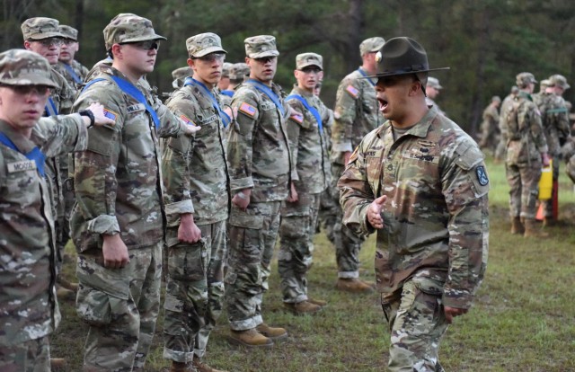 Infantry recruits with Bravo Company, 1st Battalion, 50th Infantry Regiment, get in formation following a sandbag race during the First 100 Yards at Fort Benning, Georgia, March 30, 2023. The 90-minute event teaches new recruits how to quickly work together to accomplish the mission. 