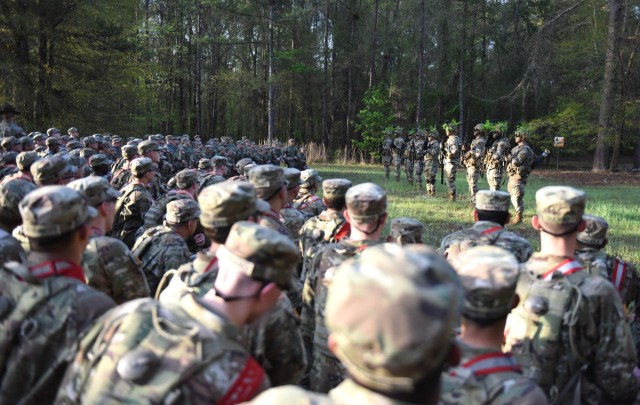 Infantry recruits with Bravo Company, 1st Battalion, 50th Infantry Regiment, observe the Hooah squad during the First 100 Yards at Fort Benning, Georgia, March 30, 2023. The 90-minute event teaches new recruits how to quickly work together to accomplish the mission. 