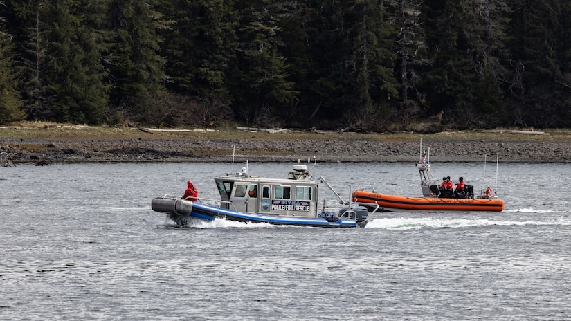 Personnel operate a Coast Guard inflatable boat and a small Sitka Police/Fire/Rescue boat in water.