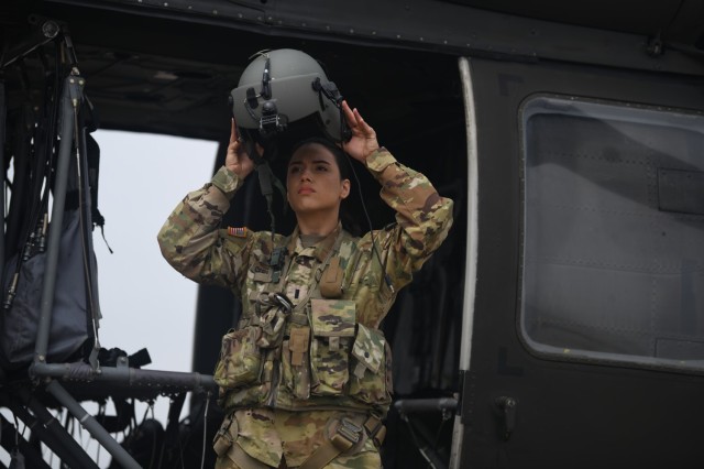 First Lt. Georgia Cervantes, a UH-60 Black Hawk pilot, straps on her helmet at Fort Cavazos' air Field on March 9, 2023. Cervantes was a dancer, swimmer and rugby player as a youth.
