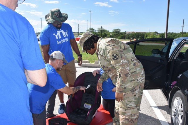 Pfc. K'Terri Miller, 13th Armored Corps Sustainment Command, listens as volunteers from the Family Advocacy Program explain the proper way to use a child car seat. Miller was surprised to learn that one of her car seats was expired, but FAP volunteers made sure she left with a new one May 19, 2023, at Fort Cavazos. (U.S. Army photo by Janecze Wright, Fort Cavazos Public Affairs)