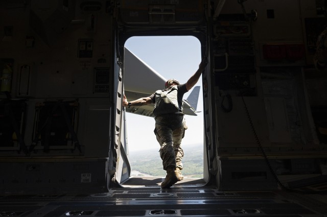 A Basic Airborne Course jumpmaster checks to see if the area is clear during a static-line jump from a C-130 cargo aircraft at Fort Benning, Georgia, March 30. The three-week course teaches service members from every military branch how to safely conduct airborne operations. (U.S. Army photo by Staff Sgt. Dustin Biven)