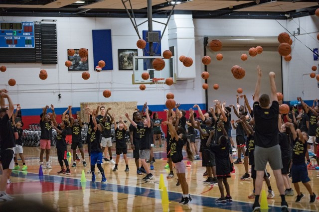 Basketballs fly through the air as the Marcus Smart Basketball Clinic participants practice proper shooting form June 24, 2023, on Fort Cavazos. The children also practiced ball handling techniques and rotated through different drill stations before competing five versus five.  (U.S. Army photo by Blair Dupre, Fort Cavazos Public Affairs)