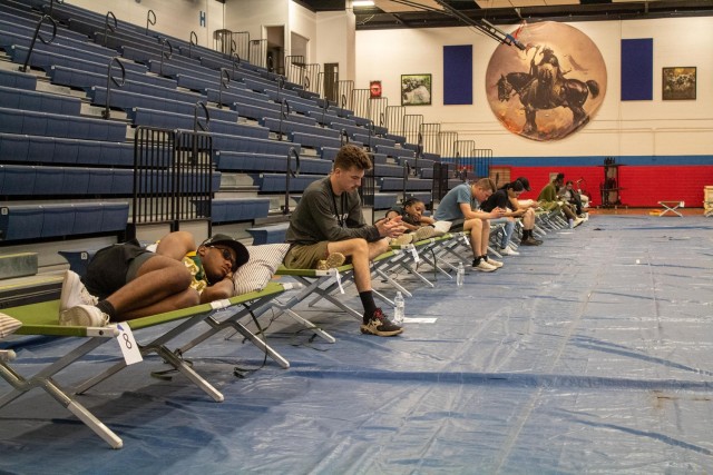 Role players relax in cots in Abrams Physical Fitness Center, following a simulated evacuation of housing residents during the full-scale exercise July 11. Some exercise evacuees were treated for heat related symptoms or transported to Carl R. Darnall Army Medical Center, while others were fed and waited for word as to when they could return to their homes. (U.S. Army photo by Samantha Harms, Fort Cavazos Public Affairs)