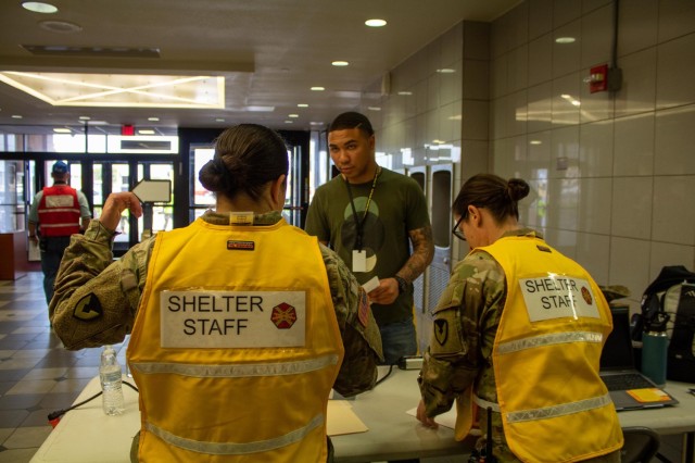 Pvt. Evan Hayles, an evacuated role player with III Armored Corps, speaks with two of the shelter staff during his check-in July 11 at Abrams Physical Fitness Center, which was deemed as the evacuation site for the full-scale exercise that Fort Cavazos conducted. Hayles was one of many role players who were evacuated; he also had to register his two cats and visit Carl R. Darnall Army Medical Center for treatment. (U.S. Army photo by Samantha Harms, Fort Cavazos Public Affairs)