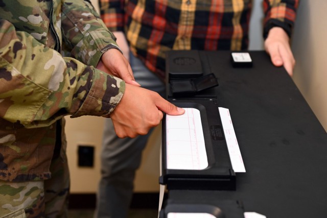 Sgt. Benjamin Gregory, center, a military police investigator, and Pvt. Mikaela Flores, an MP officer, both assigned to the 247th MP Detachment, conduct fingerprint training at Torii Station, Okinawa, July 19, 2023. The detachment, which is comprised of 45 Soldiers, recently transitioned from the 10th Support Group to U.S. Army Garrison Okinawa as part of a move to help streamline its mission.