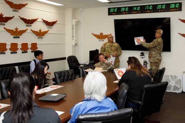 A group of master labor contractors assigned to U.S. Army Medical Department Activity-Japan receive a safety briefing before flying aboard a UH-60 Black Hawk helicopter during an employee appreciation day at Camp Zama, Japan, July 20, 2023. The event included an area orientation flight over nearby U.S. military health facilities and a pot luck lunch for the employees at the BG Sams U.S. Army Health Clinic.