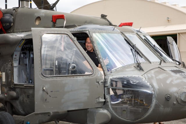 Hiroaki Soma, a housekeeper at BG Sams U.S. Army Health Clinic, poses for a photo while inside a UH-60 Black Hawk helicopter during an employee appreciation day for U.S. Army Medical Department Activity-Japan employees at Camp Zama, Japan, July 20, 2023. The event included an area orientation flight over nearby U.S. military health facilities and a pot luck lunch for the employees at the clinic.