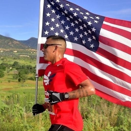 man running while carrying the American flag