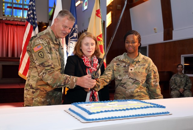 Lt. Col. Mark Olson, left, deputy command chaplain for U.S. Army Japan; Jenifer L. Peterson, center, deputy commander of U.S. Army Garrison Japan; and Spc. Jada Burnett, a religious affairs specialist, help cut a cake as part of a ceremony celebrating the Camp Zama Chapel's 70 years of service and the U.S. Army Chaplain Corps' 248-year anniversary at the chapel July 28, 2023.