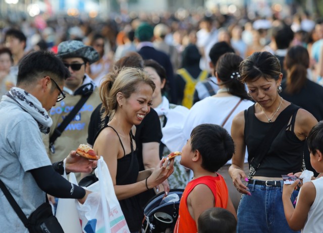 Japanese guests try some pizza during the Bon Odori festival at Camp Zama, Japan, Aug. 5, 2023. About 20,000 people attended this year's event, which honors the departed spirits of one’s ancestors. The traditional Japanese festival has been celebrated at Camp Zama since 1959.