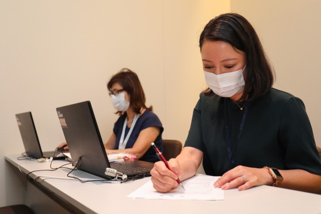 Mieko Yonaha, left, and Nozomi Akutsu, who are translators in the Civilian Health Care Navigator Program, sit at their desk inside the lobby of Zama General Hospital in Zama, Japan, Sept. 11, 2023. The program, which falls under U.S. Army Japan, will officially begin Oct. 2 to assist Department of Defense civilians, contractors and their dependents receive medical care at the hospital. 