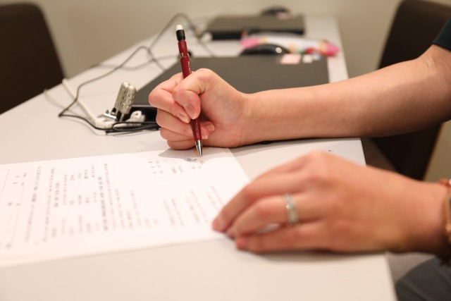 Nozomi Akutsu, a translator in the Civilian Health Care Navigator Program, works at her desk inside the lobby of Zama General Hospital in Zama, Japan, Sept. 11, 2023. The program, which falls under U.S. Army Japan, will officially begin Oct. 2 to assist Department of Defense civilians, contractors and their dependents receive medical care at the hospital.