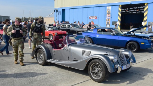 CAB Fest: Military policemen look at different classic cars and are stopped at a silver convertible to admire it. 