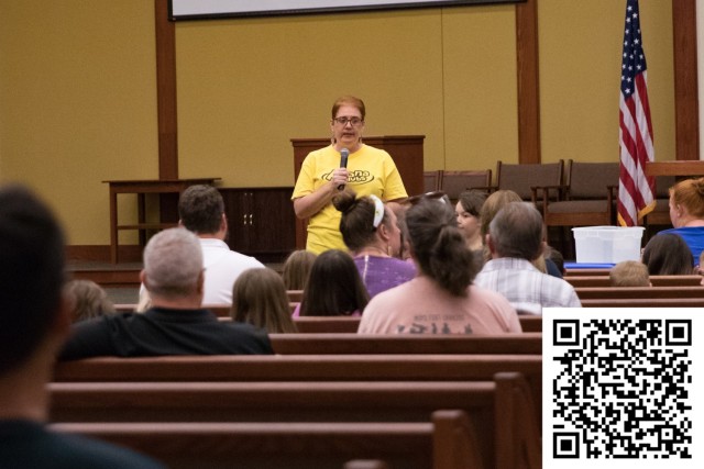 Renee Foley, Awana Club commander, speaks to children and parents on the first night of Community Connections Sept. 7. The Awana Club is in need of volunteers. For more information on how to volunteer scan the QR code pictured above. (U.S. Army photo by Blair Dupre, Fort Cavazos Public Affairs)