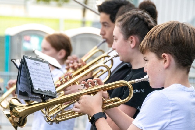 Invictus Games 2023: Four middle school trumpet players performing during a concert outside.