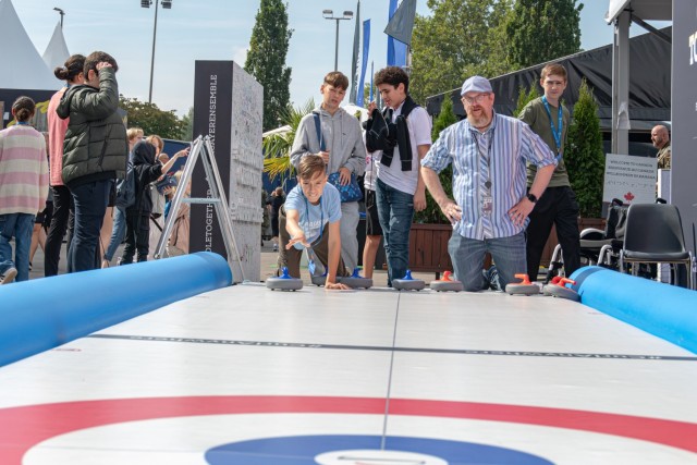 Invictus Games 2023: A child throws a curling stone as a teacher watches. 