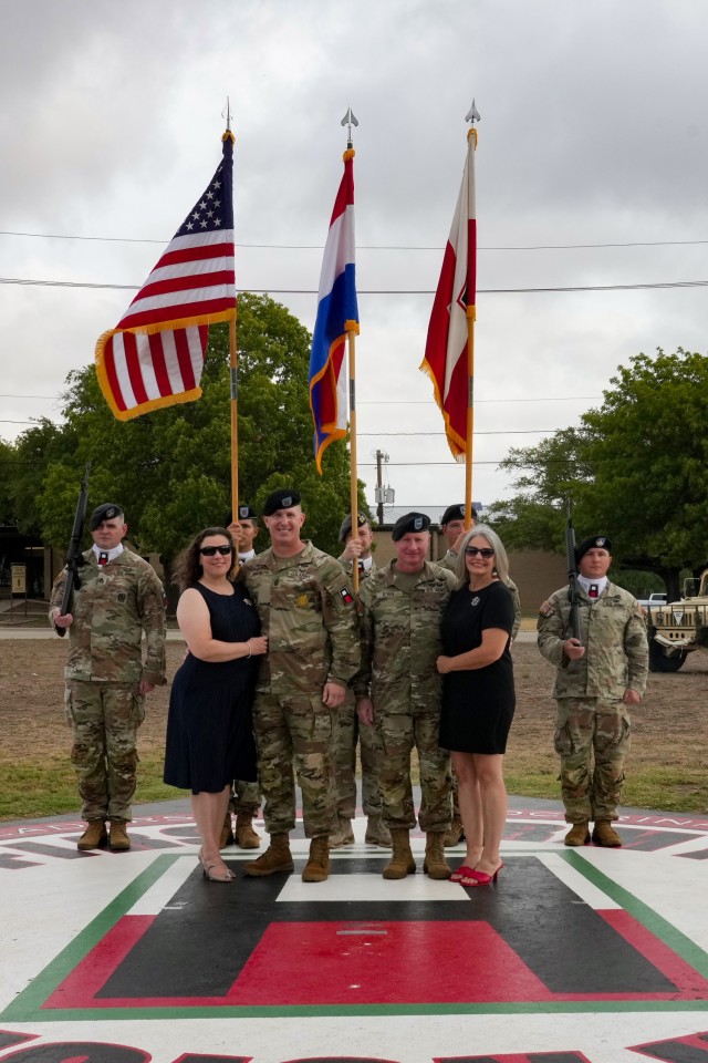 (From left) First Army Division West’s incoming Command Sgt. Maj. Vincent Simonetti and his wife Lisa Simonetti, and Commander Brig. Gen. William A. Ryan III and his wife Lorry Ryan, pose for a photo in front of the division color guard at an Assumption of Responsibility Ceremony held at Fort Cavazos Sept. 21.