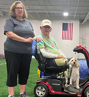 Amputee Veteran and dog and their ribbons