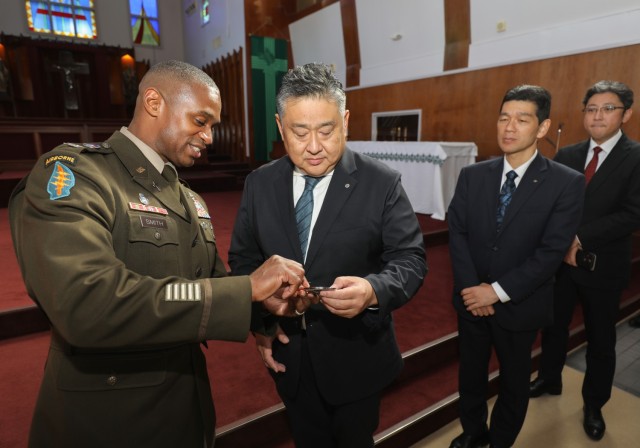 Col. J.P. Smith, left, command chaplain for U.S. Army Japan, provides a military coin to Atsushi Ushio, director of the Edification Department at the Association of Shinto Shrines, during a visit at Camp Zama, Japan, Nov. 9, 2023. Several Shinto priests and members from the Association of Shinto Shrines toured the installation as part of an ongoing effort to increase interfaith dialogue with unit ministry teams.