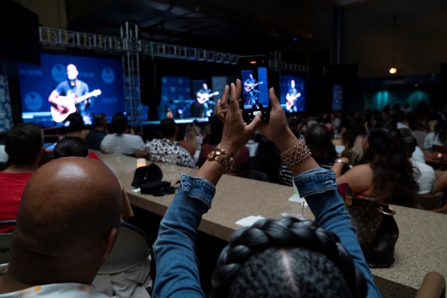 Grammy-nominated artist Brian McKnight delivers an emotional performance of "Red, White, and Blue," his final song of the night, dedicated to the service members and their families at Schofield Barracks. Seated center stage with his custom-built guitar, McKnight's soulful tribute resonates through a crowd of America's finest, echoing his appreciation for their sacrifice and dedication.