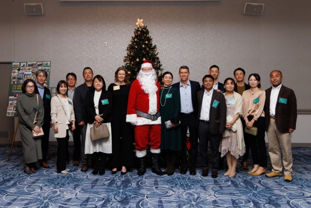 Col. Marcus Hunter, commander of U.S. Army Garrison Japan, and his wife, Caren, take a photo with Japan Ground Self-Defense Force members during a holiday reception inside the Camp Zama Community Club at Camp Zama, Japan, Dec. 8, 2023. More than 160 local community leaders and Camp Zama personnel came together for the festive event.