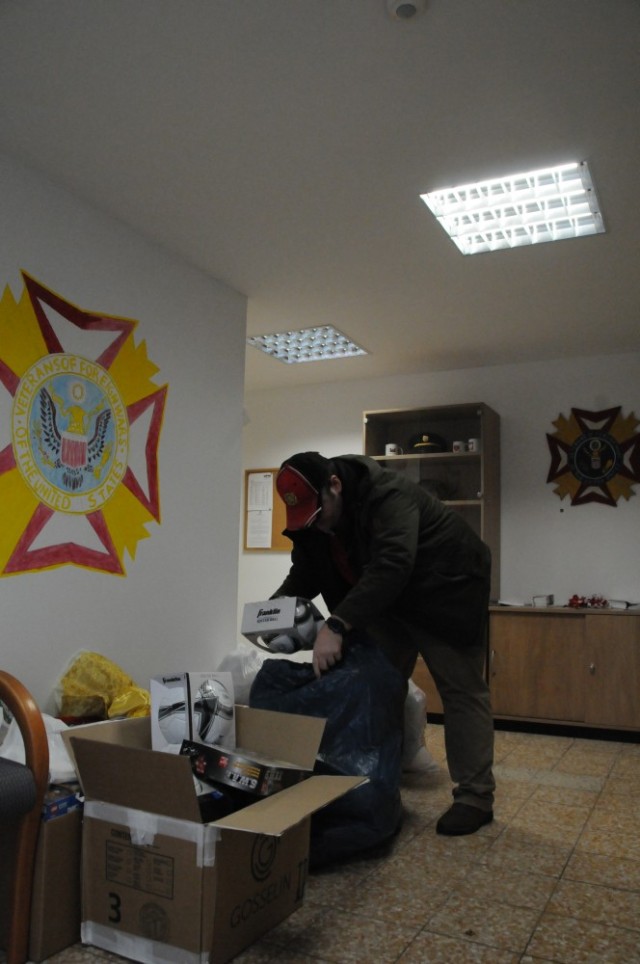 JOINT MULTINATIONAL READINESS CENTER, Germany -- Clinton L. Medovich, quartermaster for Veterans of Foreign Wars Post 10557 at Hohenfels, Germany, unloads a soccer ball to donate Dec. 21, 2023 to children of the Pedagogical Center St. Josef at Parsberg, Germany. The VFW received toys from the U.S. Army Garrison Bavaria Directorate of Emergency Services, from members of the Hohenfels military community and from the Hohenfels Thrift Shop, to establish, what members of the VFW hope, what will be an annual holiday tradition. (U.S. Army photo by Bryan Gatchell, USAG Bavaria Public Affairs)