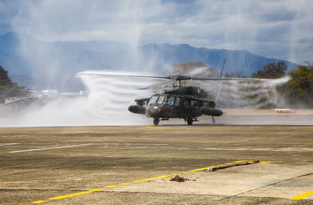 A UH-60 Black Hawk helicopter flown by Chief Warrant Officer 4 Rick Dean, assigned to U.S. Army Aviation Battalion–Japan, is sprayed with water after Dean's final flight at Camp Zama's Kastner Airfield in Japan, Dec. 1, 2023. Dean served 26 years in the Army, much of them as a helicopter pilot.