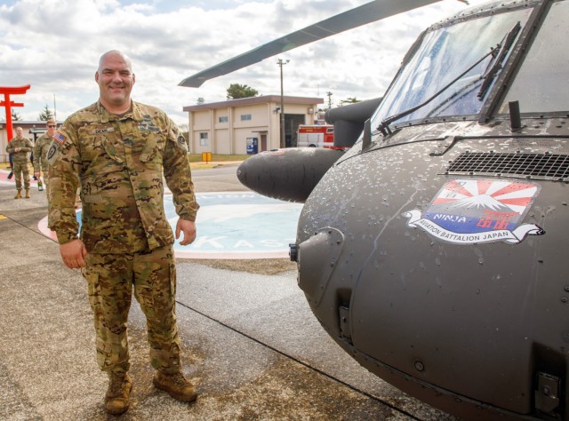 Chief Warrant Officer 4 Rick Dean, assigned to U.S. Army Aviation Battalion–Japan, poses for a photo next to his UH-60 Black Hawk helicopter after completing his final flight at Camp Zama's Kastner Airfield in Japan, Dec. 1, 2023. Dean served 26 years in the Army, much of them as a helicopter pilot.