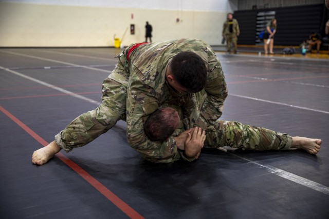 U.S. Spc. Kobe Yager, a motor transport operator assigned to 541st Division Sustainment Support Battalion, 1st Infantry Division Sust. Brigade, 1st Inf. Div. (red belt) puts Spc. Tyler Lloyd, an aircraft powertrain repairer assigned to 2nd General Support Aviation Battalion, 1st Aviation Regiment, 1st Combat Aviation Brigade, 1st Inf. Div. (blue belt), in a submission hold during the Victory Week “Sgt. 1st Class Matthew Leonard” Combatives Tournaments tournament at Long Fitness Center on Fort Riley, Kansas, June 12, 2023. Yager won the matchup against, moving on to the heavyweight semi-finals on June 13, 2023. (U.S. Army photo by Spc. Joshua Holladay)