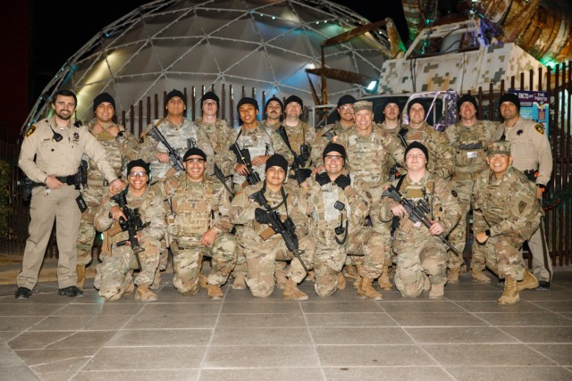 Soldiers from the 1st Squadron, 221st Cavalry pose for a photo with Brig. Gen. Troy Armstrong, the assistant adjutant general of the Nevada Army National Guard, and State Command Sgt. Maj. Dennis Basilio, the command sergeant major of the Nevada Army National Guard, in Las Vegas, Nevada, Dec. 31, 2023. The soldiers worked closely with local law enforcement to bolster security during the New Year's Eve celebrations. (U.S. Army National Guard photo by Spc. Adrianne Lopez)(Photo used tonal adjustments and cropped to enhance subjects)