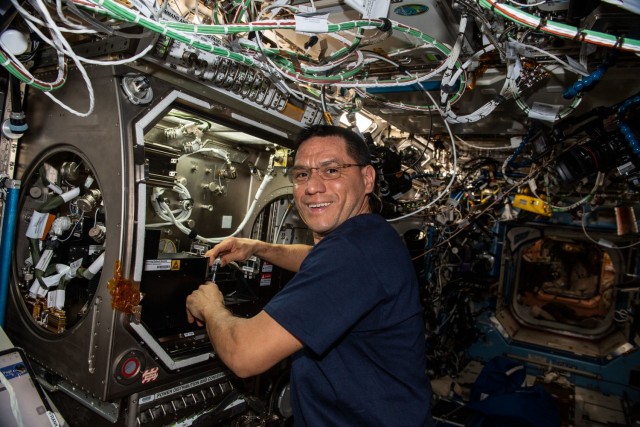 NASA astronaut and Expedition 68 Flight Engineer Frank Rubio sets up the new Particle Vibration experiment inside the Destiny laboratory module’s Microgravity Science Glovebox. The physics study will investigate how particles organize themselves in fluids possibly advancing manufacturing techniques and providing new insights on astrophysics.