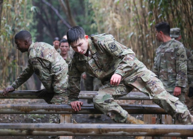 Cadets Alexander Fitzgerald, front, and Jordan Cobb tackle an obstacle while completing a confidence course at Camp Zama, Japan, March 12, 2024. Soldiers from the 35th Combat Sustainment Support Battalion hosted a field day to familiarize Zama Middle High School cadets with some aspects of Army life.