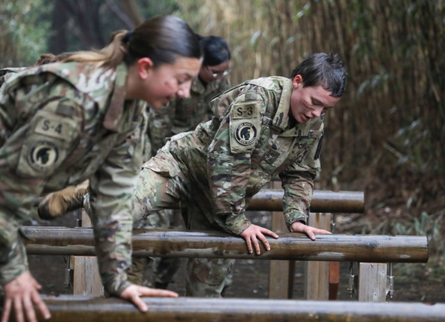 Cadet Liliana Fennessey, left, and Corban Olson tackle an obstacle while completing a confidence course at Camp Zama, Japan, March 12, 2024. Soldiers from the 35th Combat Sustainment Support Battalion hosted a field day to familiarize Zama Middle High School cadets with some aspects of Army life.