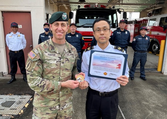 Col. Marcus Hunter, left, U.S. Army Garrison Japan commander, presents an “Employee of the Quarter” award to Tomokazu Matsuura, a fire protection inspector, during Hunter’s recent two-day trip to the Kure Ammunition District in Hiroshima, Japan.