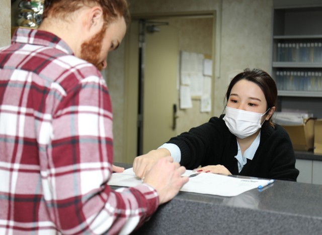 Mai Nemoto, a front desk clerk at the Camp Zama Army Lodging in Japan, assists a guest checking out of the facility March 5, 2024. The lodging team recently won the fiscal 2023 Lodging Operation of the Year Award for medium-sized facilities.