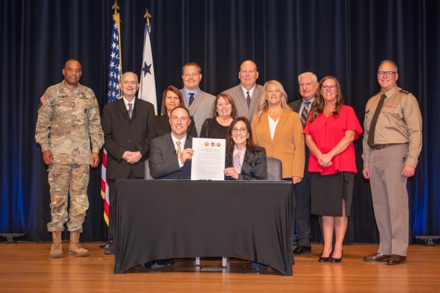 Dr. Chad Coauette, CEO of the Sourcewell company (seated left), and Ms. Rachel Jacobson, Assistant Secretary of the U.S. Army Installations, Energy and Environment (seated right), hold up the Sourcewell Intergovernmental Support Agreement proclamation during a signing ceremony in the Pentagon auditorium, Arlington, Va., April 10, 2024.  This first-of-its-kind sourcing agreement with the Sourcewell company allows for base supplies to multiple army installations while saving money, efficiently streamlining the supply process.  (U.S. Army photo by Bernardo Fuller)