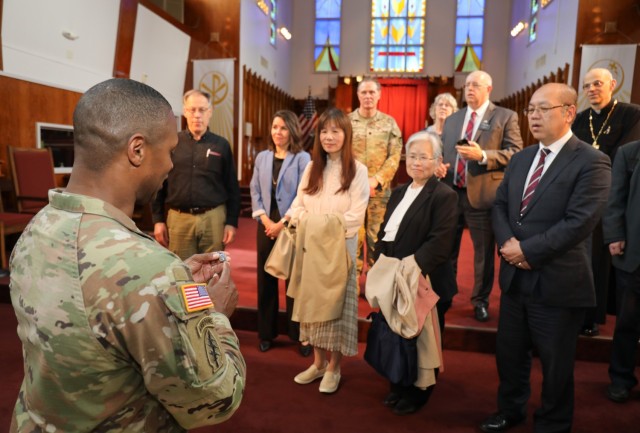 Col. J.P. Smith, left, command chaplain for U.S. Army Japan, explains his military coin before providing them to members of the Tokyo Interfaith Council during their visit to Camp Zama, Japan, April 11, 2024. Council members and two Navy chaplains toured the installation while everyone exchanged information and ideas on how they can assist each other. 