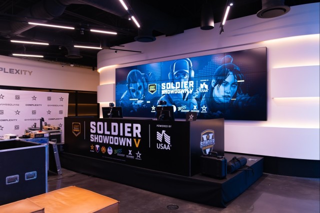 A counter with "Soldier Showdown V" written on it with a large TV screen in the background.