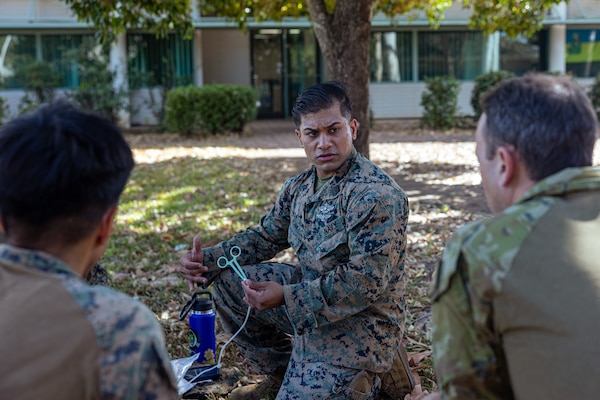 U.S. Navy Petty Officer 2nd Class Abm Asim, center, a hospital corpsman with Marine Rotational Force – Darwin 24.3, shows Seaman Albert Romarate, left, a hospital corpsman with Combat Logistics Battalion 5 (Reinforced), MRF-D 24.3, and Australian Army Sgt. Sean O’Regan, a medical technician with 1st Health Battalion, 2nd Health Brigade, how to properly prepare medical equipment to draw blood during Valkyrie emergency fresh whole blood transfusion training at Robertson Barracks, Darwin, NT, Australia, May 16, 2024. The Valkyrie program enables military units to self-supply blood through emergency donor panels by adequate training, rehearsal, and preparation, gaining the skills and knowledge to efficiently collect whole blood, and conduct blood transfusions in the event of a casualty. Asim is a native of Florida. Romarate is a native of California. (U.S. Marine Corps photo by Cpl. Juan Torres)