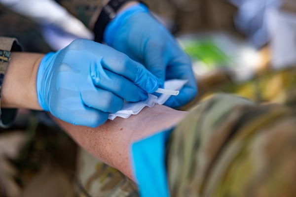 U.S. Navy Petty Officer 3rd Class Ariana Buckley, a hospital corpsman with Combat Logistics Battalion 5 (Reinforced), Marine Rotational Force – Darwin 24.3, simulates drawing blood during Valkyrie emergency fresh whole blood transfusion training at Robertson Barracks, Darwin, NT, Australia, May 16, 2024. The Valkyrie program enables military units to self-supply blood through emergency donor panels by adequate training, rehearsal, and preparation, gaining the skills and knowledge to efficiently collect whole blood, and conduct blood transfusions in the event of a casualty. Buckley is a native of New York. (U.S. Marine Corps photo by Cpl. Juan Torres)