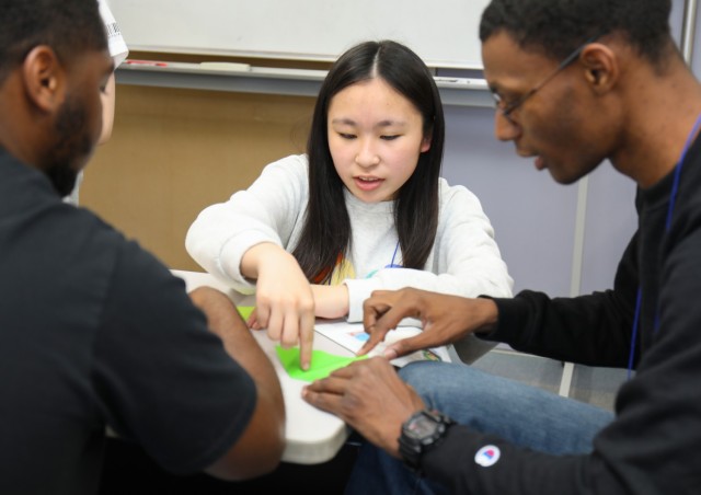Ishiha Matsubara, center, teaches Cpls. Kevin Atkins, left, assigned to 38th Air Defense Artillery Brigade, and Tyrell Heyward, assigned to 78th Signal Battalion, how to fold an origami during a language and cultural event at Zama City Hall, Japan, May 3, 2024. The Camp Zama volunteers helped a group of students get ready for an exchange trip this summer to Zama City’s sister city in Tennessee.
