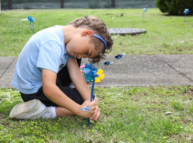 Bradley Turner plants a pinwheel in front of the library at Sagamihara Family Housing Area, Japan, during an event in support of National Child Abuse Prevention Month April 30, 2024. 