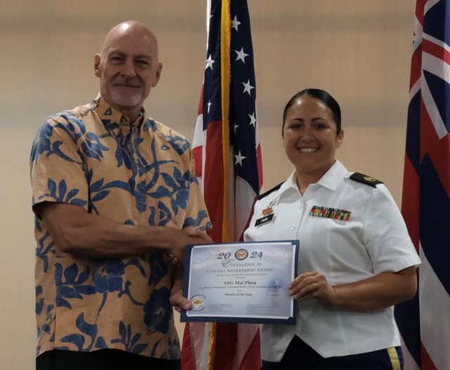 Army Staff Sgt. Mai Phan, Better Opportunities for Single Soldiers President, U.S. Army Garrison Hawaii (right) accepts the Mentor of the Year Excellence Award from William Jessup, Acting U.S. Marshall, District of Hawaii at the Federal Executive Board’s Annual Excellence in Federal Government Awards ceremony at the Tradewinds facility on Joint Base Pearl Harbor Hickam, Hawaii on May 10.
