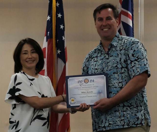 On behalf of Hilary Kapua Kawelo, Natural Resources Specialist, U.S. Army Garrison Hawaii, Matthew Foster (right) accepts the Exceptional Community Service Excellence Award from Melissa Naguwa, Honolulu Passport Agency at the Honolulu-Pacific Federal Executive Board’s Annual Excellence in Federal Government Awards ceremony at the Tradewinds facility on Joint Base Pearl Harbor Hickam, Hawaii on May 10.