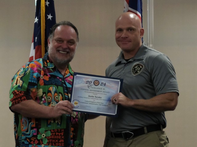 Justin Turnbo, Fire Management Specialist, U.S. Army Garrison Hawaii (right) accepts the Federal Employee of the Year – Professional, Administrative, Technical Excellence Award from Howard Vickers, Chief of Human Resources, U.S. Army Installation Management Command-Pacific at the Honolulu-Pacific Federal Executive Board’s Annual Excellence in Federal Government Awards ceremony at the Tradewinds facility on Joint Base Pearl Harbor Hickam, Hawaii on May 10.