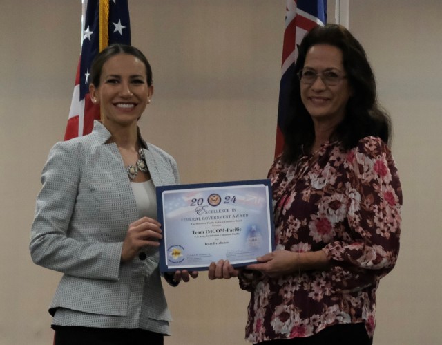 Honiala Morales, Executive Officer, U.S. Army Installation Management Command-Pacific (right) accepts the Team Excellence Award from Nanea Vasta, Federal Security Director, Transportation Security Agency at the Honolulu-Pacific Federal Executive Board’s Annual Excellence in Federal Government Awards ceremony at the Tradewinds facility on Joint Base Pearl Harbor Hickam, Hawaii on May 10.