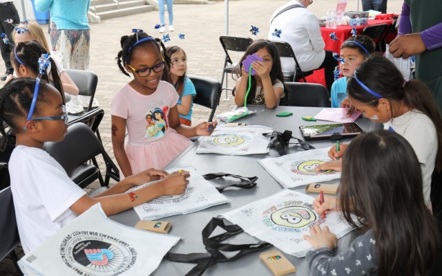 Several children do arts and crafts during a pinwheel planting event in support of National Child Abuse Prevention Month at Sagamihara Family Housing Area, Japan, April 30, 2024.