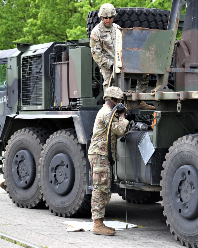 U.S. Soldiers fill a military vehicle with gas.